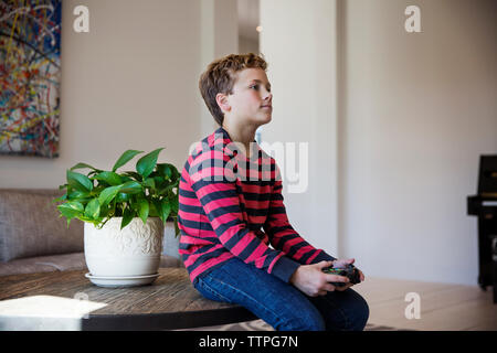 Boy playing video game at home Stock Photo