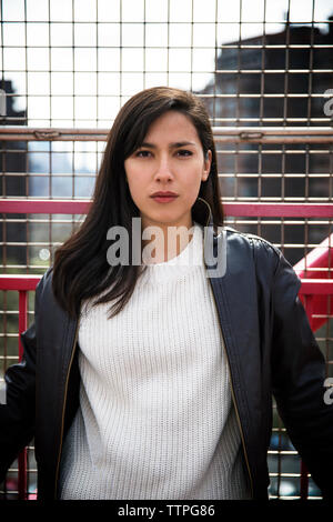 Portrait of confident beautiful woman standing on Williamsburg bridge Stock Photo