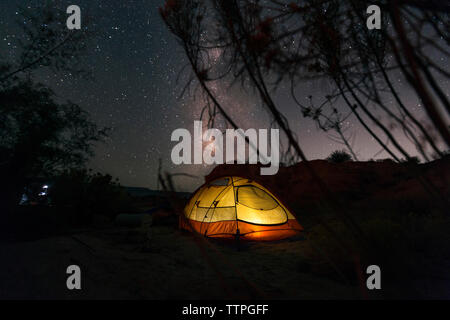 Illuminated tent on field against star field at night Stock Photo