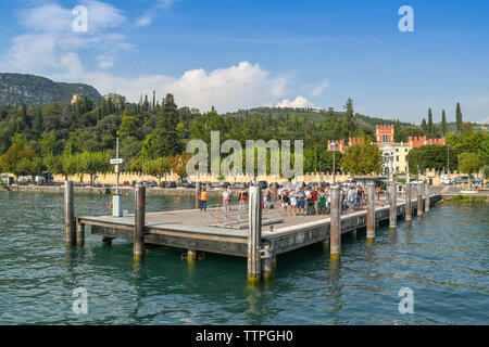 GARDA, LAKE GARDA, ITALY - SEPTEMBER 2018:  People queuing on the ferry landing stage in Garda on Lake Garda. Stock Photo