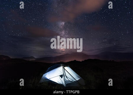 Illuminated tent on field against sky at night Stock Photo
