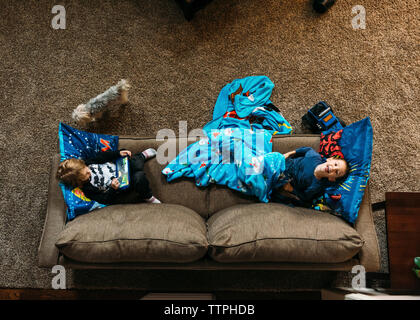 Overhead view of boys lying on sofa at home Stock Photo