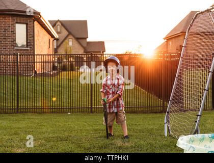 Portrait of boy with baseball bat in backyard Stock Photo