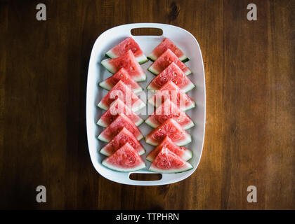 Overhead view of watermelon slices served in tray on wooden table Stock Photo