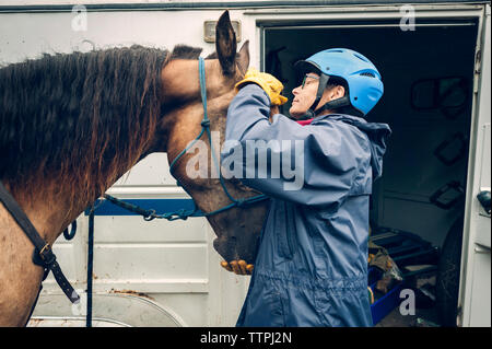 Female doctor examining horse while standing by ambulance Stock Photo