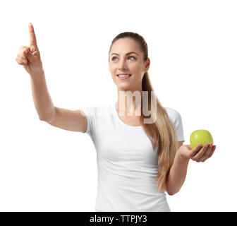 Beautiful girl with apple pointing finger, isolated on white Stock Photo