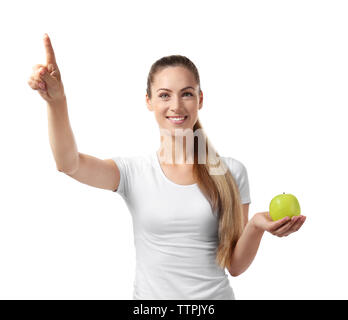 Beautiful girl with apple pointing finger, isolated on white Stock Photo