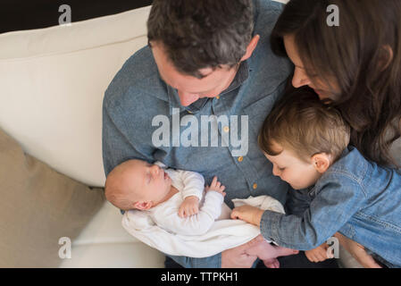 High angle view of family looking at baby boy sleeping at home Stock Photo