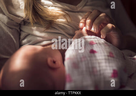 Midsection of mother breastfeeding newborn daughter at home Stock Photo