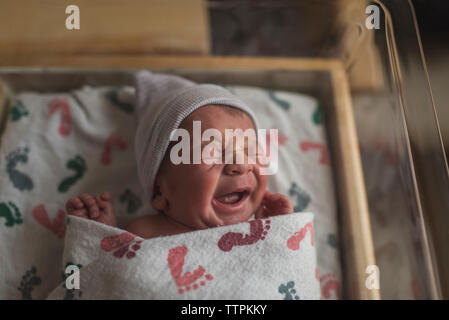 High angle view of newborn baby boy crying in crib at hospital Stock Photo