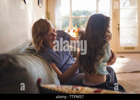 Doctor examining girl while sitting on sofa at home Stock Photo