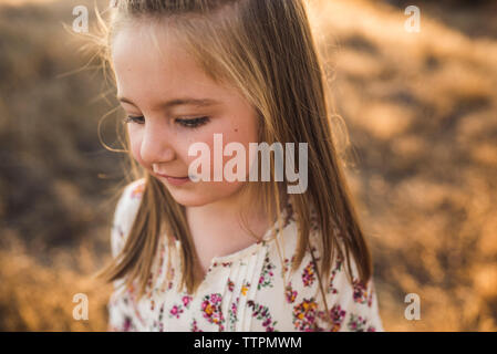 Close up portrait of young girl looking down outdoors Stock Photo