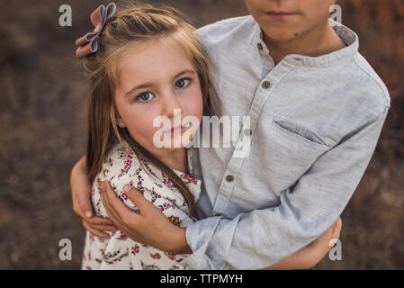 Close up of young girl embraced by brother in California field Stock Photo