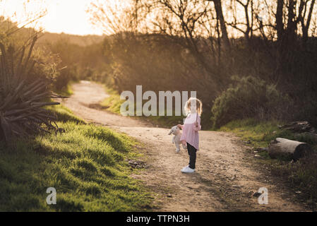 Little girl walking on trail with her stuffed animal Stock Photo