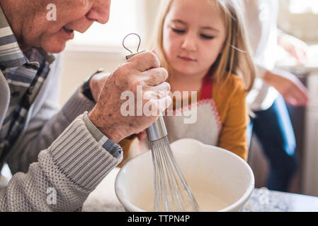 Girl and granddfather making breakfast pancakes in the kitchen Stock Photo