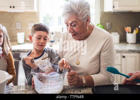 Grandson and great grandma making breakfast pancakes in the kitchen Stock Photo