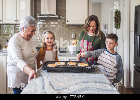 Lifestyle image of young girl and boy making breakfast Stock Photo
