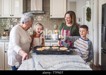 Lifestyle image of young girl and boy making breakfast Stock Photo