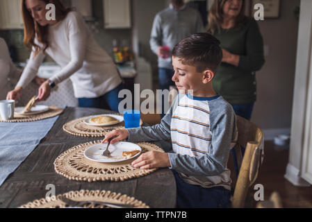 Young boy eating pancakes for breakfast