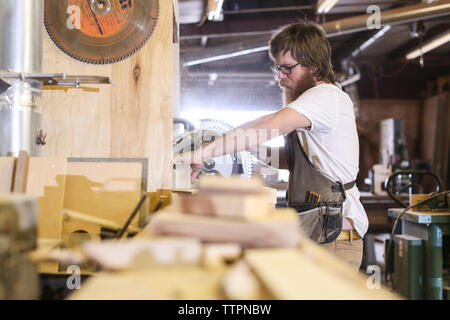 Carpenter using circular saw in workshop Stock Photo