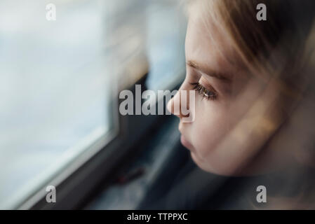 High angle view of thoughtful girl by window at home Stock Photo