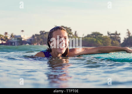 Happy young woman swimming in sea against clear sky Stock Photo