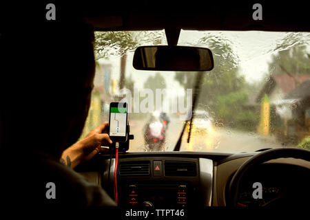 Man using navigation map on mobile phone while sitting in car Stock Photo