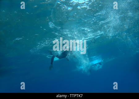 Low section of man surfing underwater in sea Stock Photo