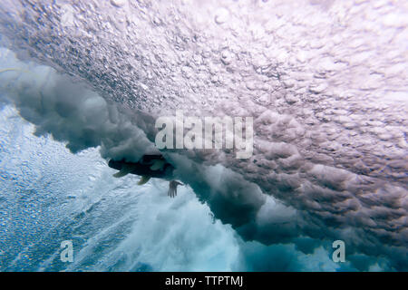 Low angle view of surfboard amidst waves breaking undersea at Maldives Stock Photo