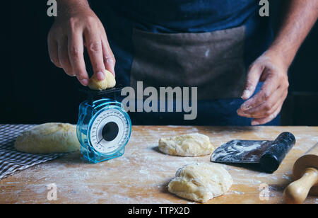 baker weighing bread dough on scale at bakery Stock Photo - Alamy