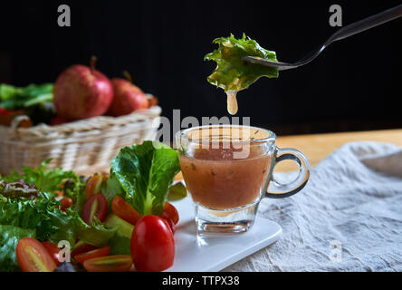 Close-up of vegetables and fruits with dip on table against black background Stock Photo