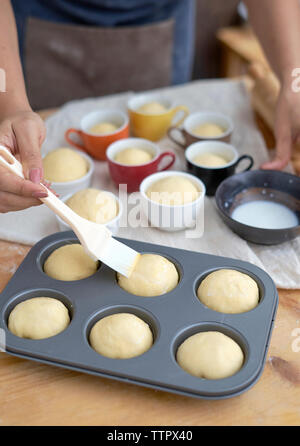 Midsection of woman preparing food in baking tray on table at home Stock Photo