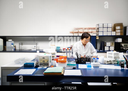 Senior female scientist doing experiment in laboratory Stock Photo