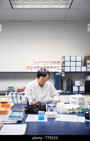 Senior female scientist using machinery in laboratory Stock Photo