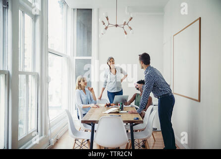 businessman explaining strategy to female colleagues in board room Stock Photo