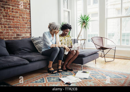 businesswomen using tablet computer on sofa in creative office Stock Photo