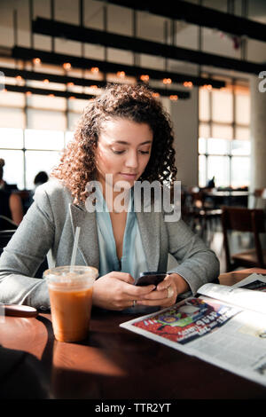 businesswoman using smart phone at cafe table Stock Photo
