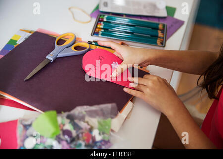 Cropped image of girl making greeting card for mother on table Stock Photo