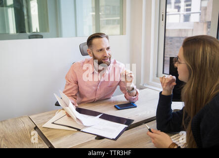 Colleagues discussing reports in office Stock Photo
