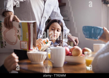 Family at table having breakfast in kitchen Stock Photo