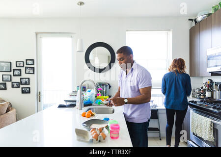 Couple working together in brightly lit kitchen Stock Photo