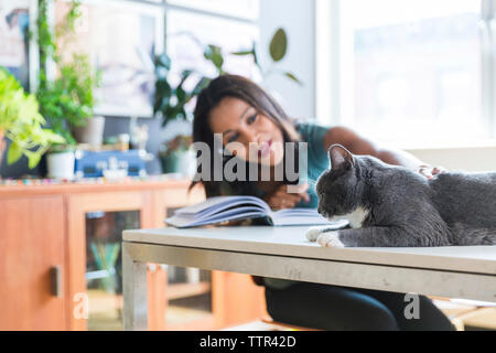 Woman petting cat at home office Stock Photo