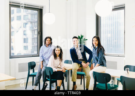 Portrait of confident business people sitting in creative office Stock Photo