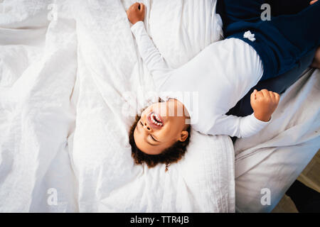 High angle view of happy boy lying on bed at home Stock Photo
