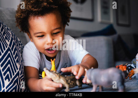Close-up of cute boy playing with toys on sofa at home Stock Photo