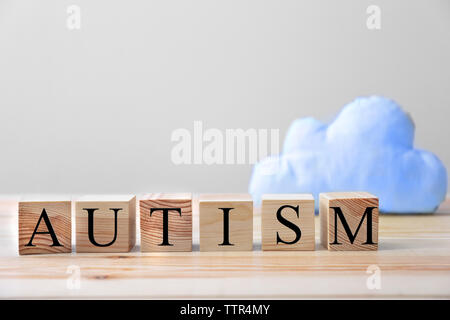 Word autism made of wooden cubes on wall background Stock Photo