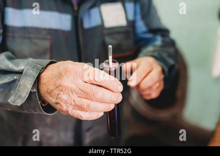 Midsection of vintner testing wine in factory Stock Photo