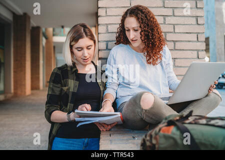 Two young students in the college using laptop Stock Photo