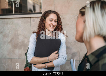 Two young students talking together in the college Stock Photo