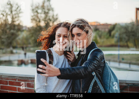 Two young student taking a selfie at the park together Stock Photo